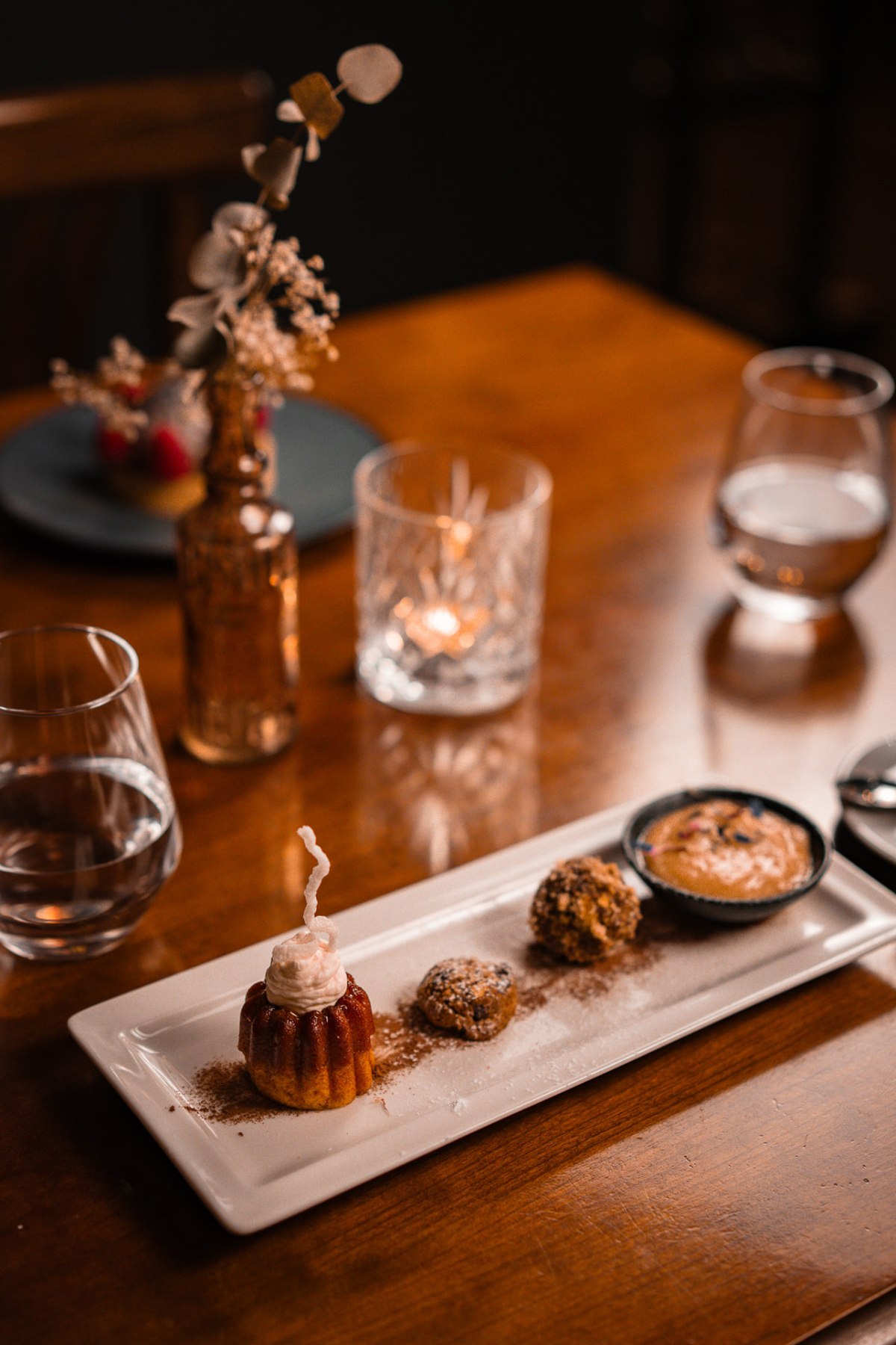 Cannelé et gourmandises sur une table éclairée à la bougie